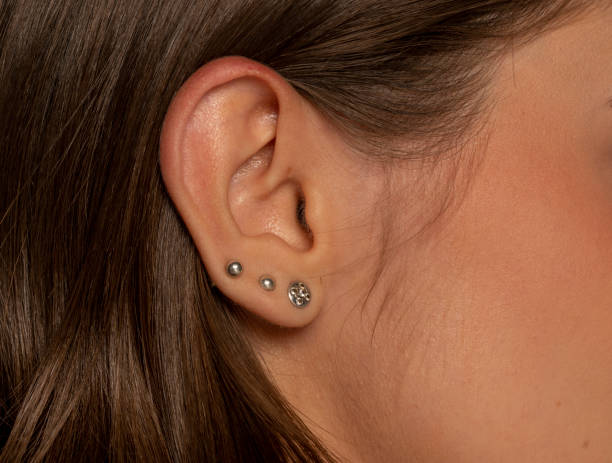 closeup of female ear with three earrings